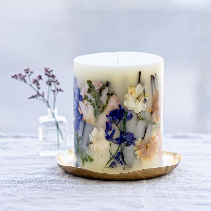 Candle with floral design on a white surface