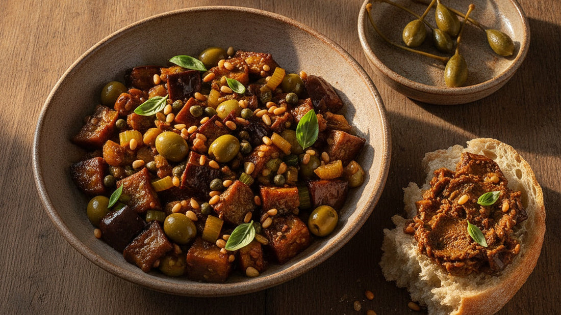 A wide shallow bowl of Sicilian caponata, glossy cubes of eggplant with celery, green olives, capers and torn basil, a few caperberries on the rim