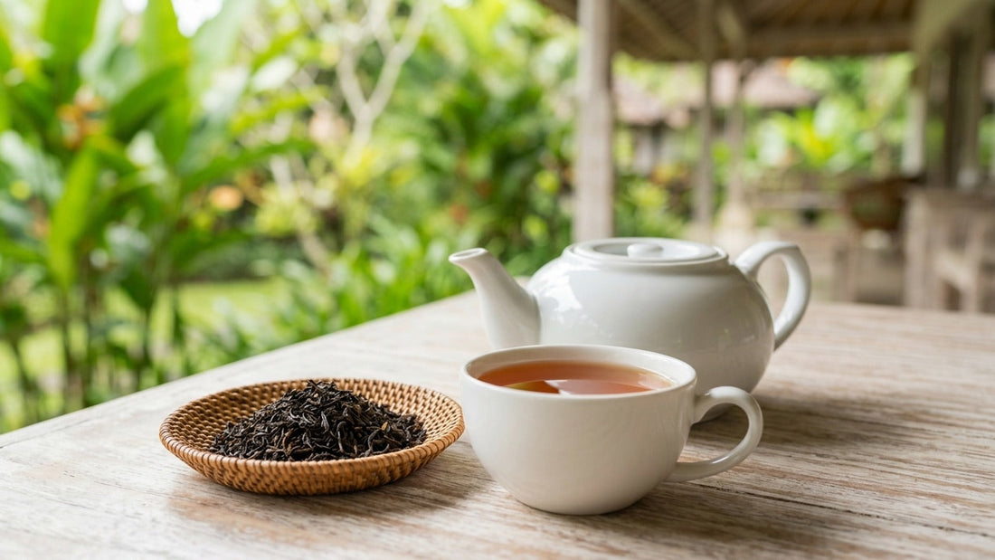 A cup of Mariage Frères Vanille des Îles black tea with a white teapot and a woven dish of loose tea on a veranda table