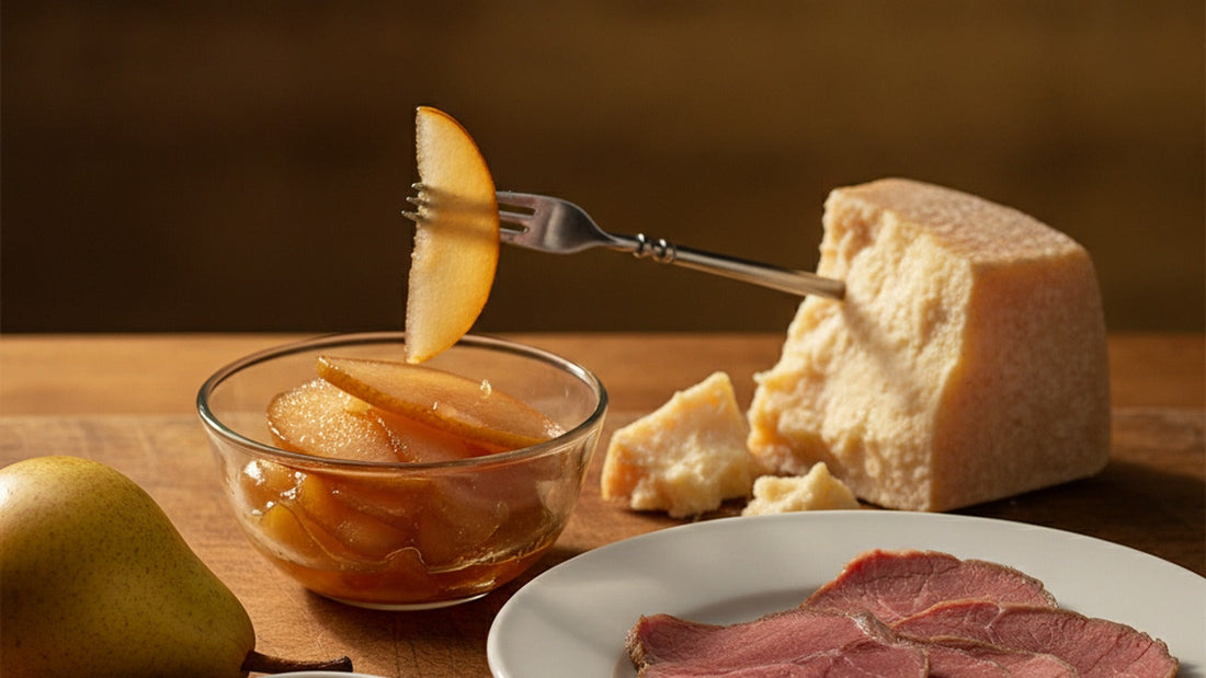 A glass bowl of translucent amber pear slices in glossy syrup beside a wedge of aged hard cheese and a few slices of boiled beef on a wooden board