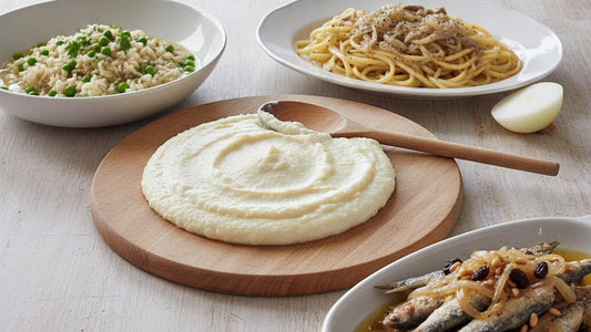 A board of soft white polenta beside fried sardines under golden onions, raisins and pine nuts, a bowl of loose rice and peas, and thick spaghetti in a pale onion and anchovy sauce
