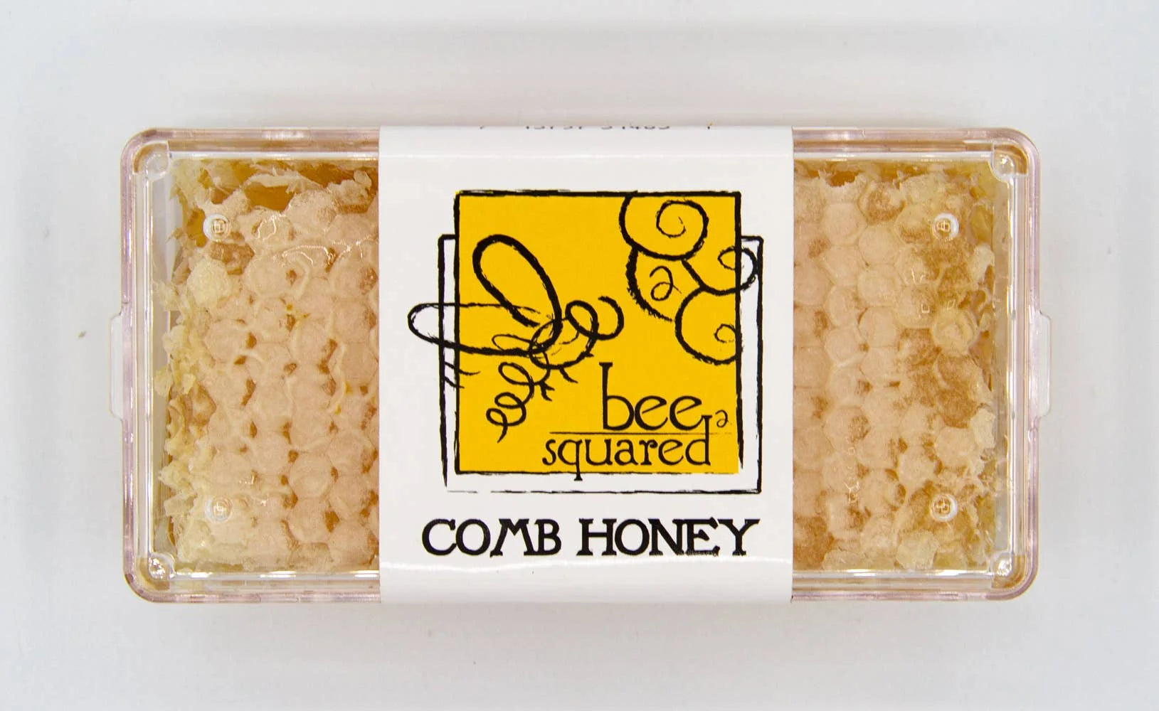 Box of comb honey with 'bee squared' label on a white background