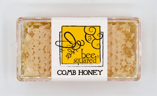 Box of comb honey with 'bee squared' label on a white background