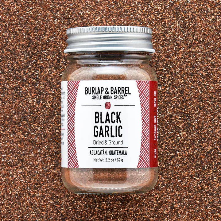 Jar of Burlap & Barrel Black Garlic on a textured brown background