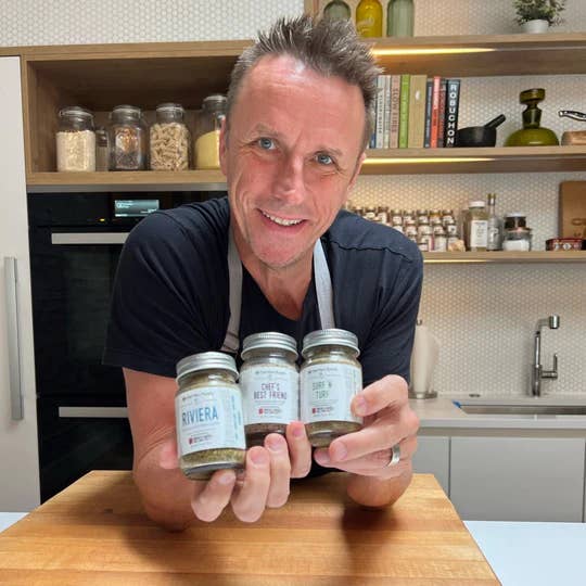 Man holding three jars labeled 'Riviera' in a kitchen setting