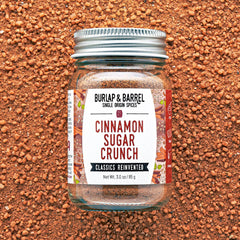 Jar of 'Cinnamon Sugar Crunch' spice mix by Burlap & Barrel on a textured brown background