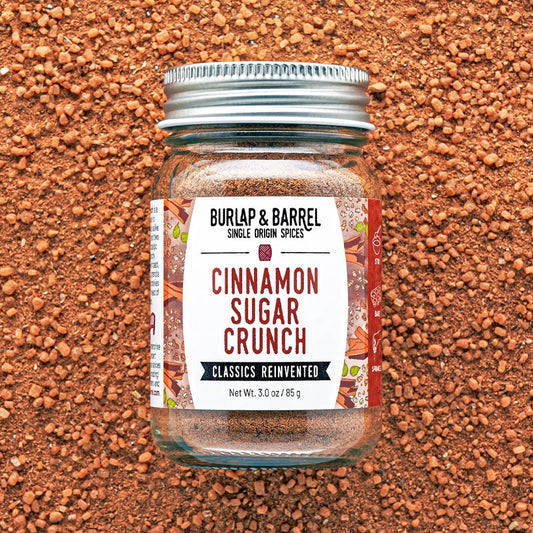 Jar of 'Cinnamon Sugar Crunch' spice mix by Burlap & Barrel on a textured brown background