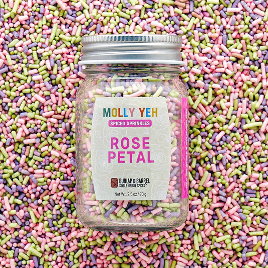 Jar of Molly Yeh Rose Petal sprinkles surrounded by colorful sprinkles