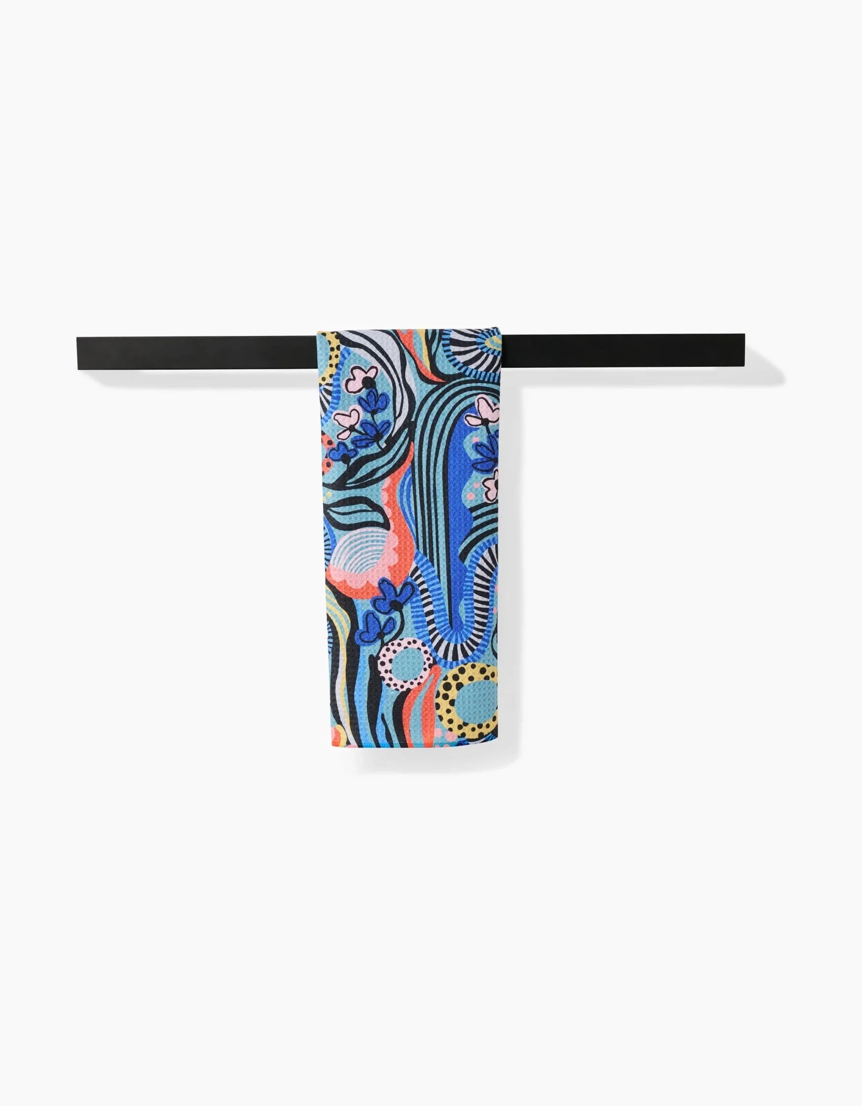 Colorful patterned towel hanging on a black rod against a white background