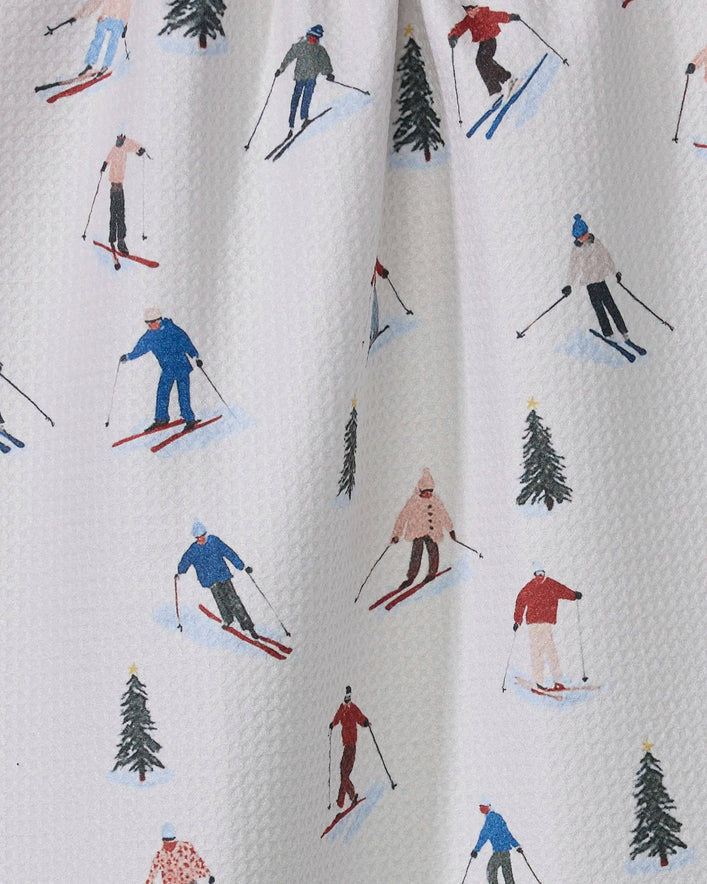 Pattern of skiers and trees on a textured fabric background