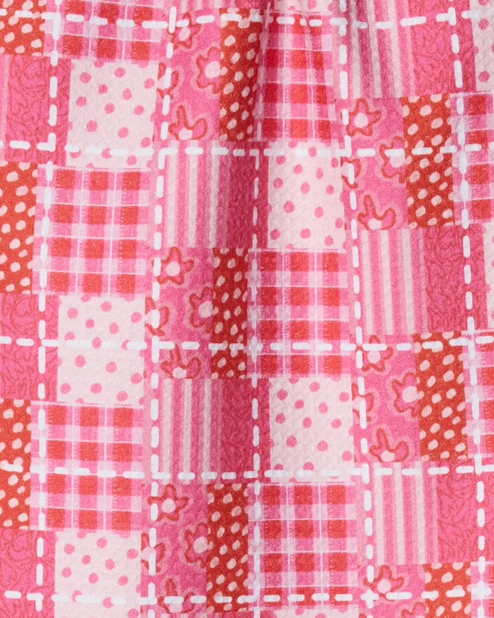 Patchwork fabric with pink, red, and white patterns