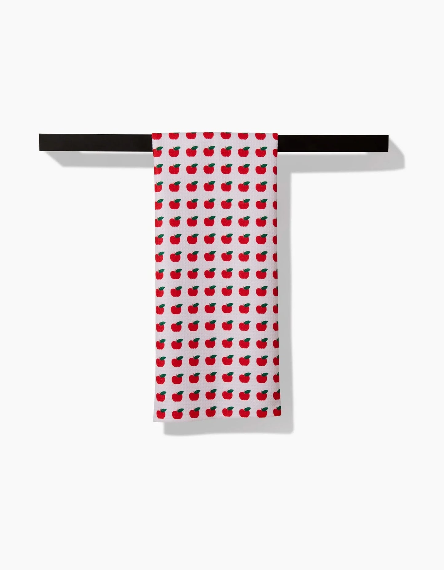 Red and white patterned towel hanging on a black rack against a white background