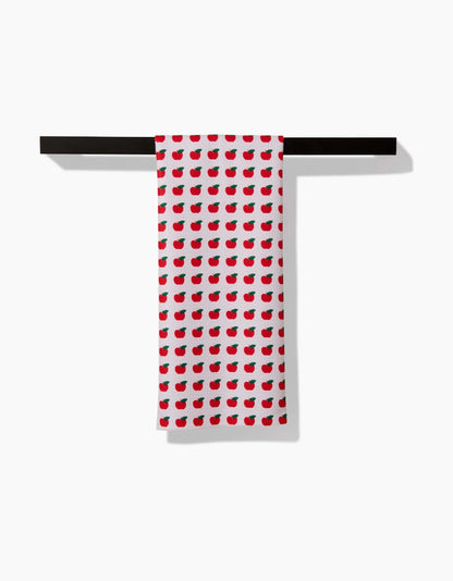 Red and white patterned towel hanging on a black rack against a white background
