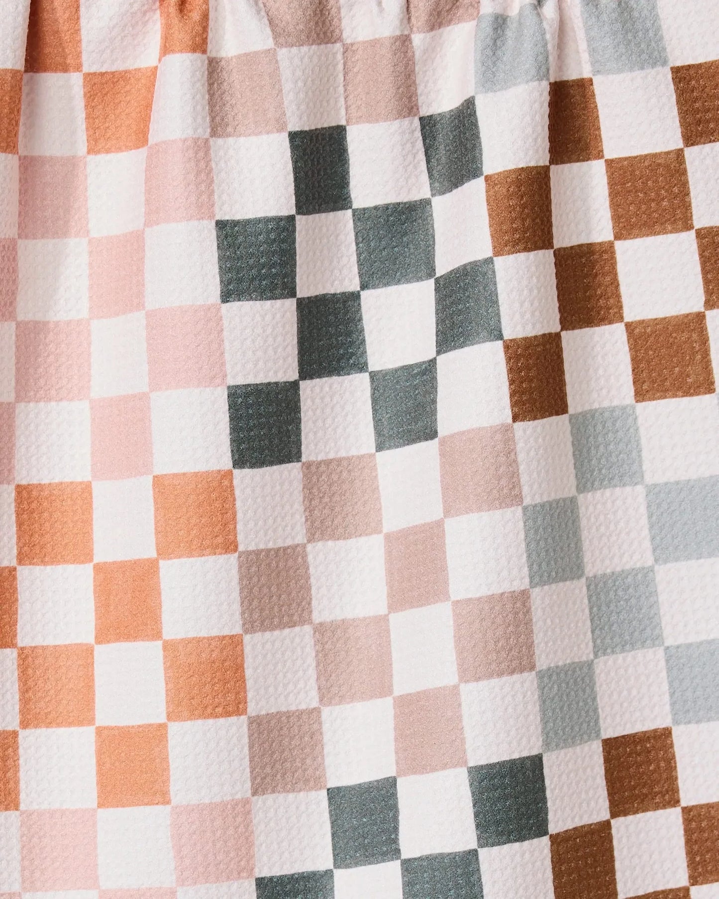 Close-up of a checkered fabric with brown, white, and gray squares.