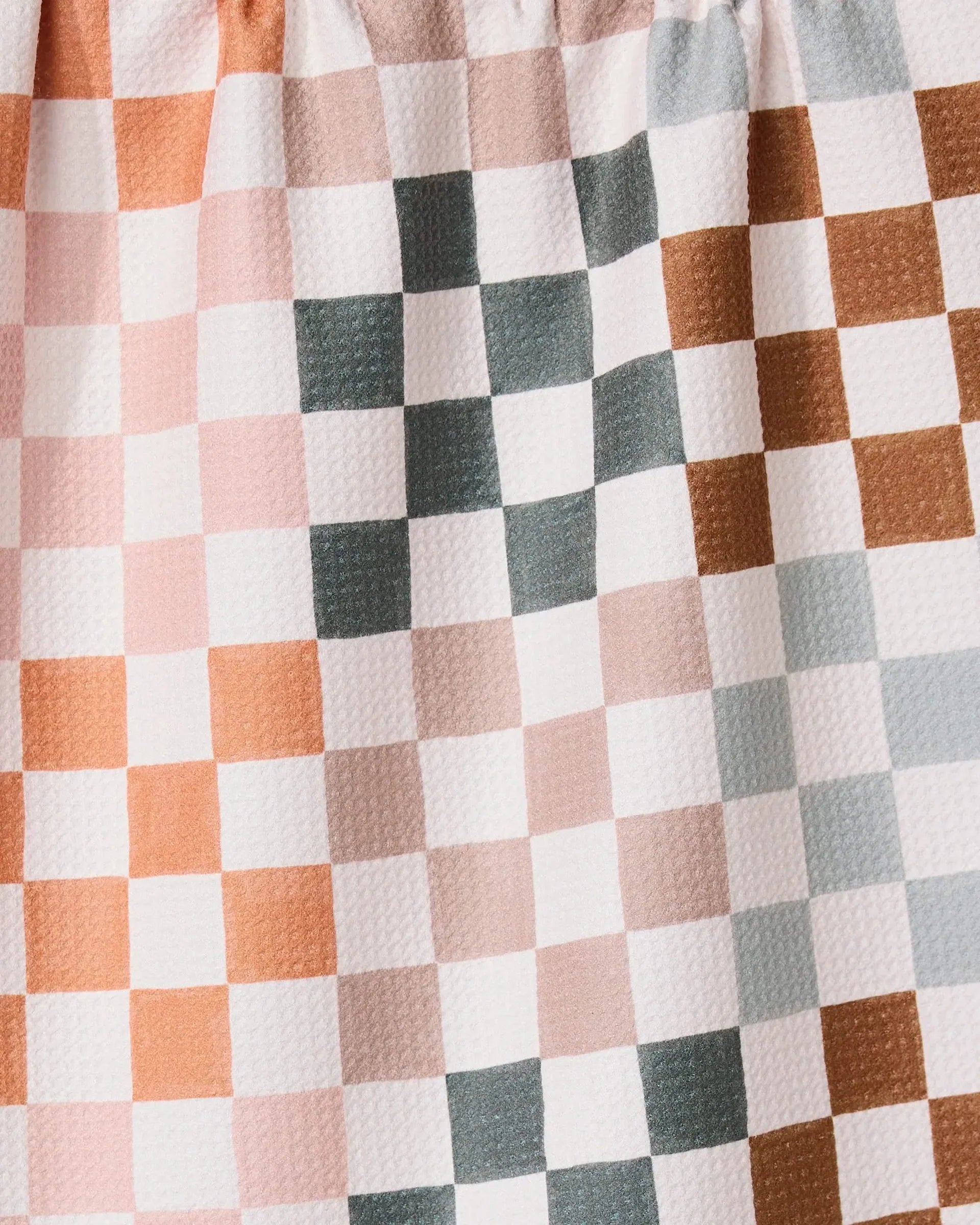 Close-up of a checkered fabric with brown, white, and gray squares.