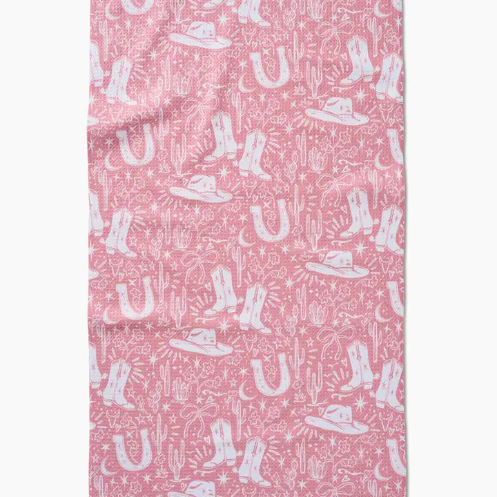 Pink fabric with white cowboy boot, hat, and cactus pattern