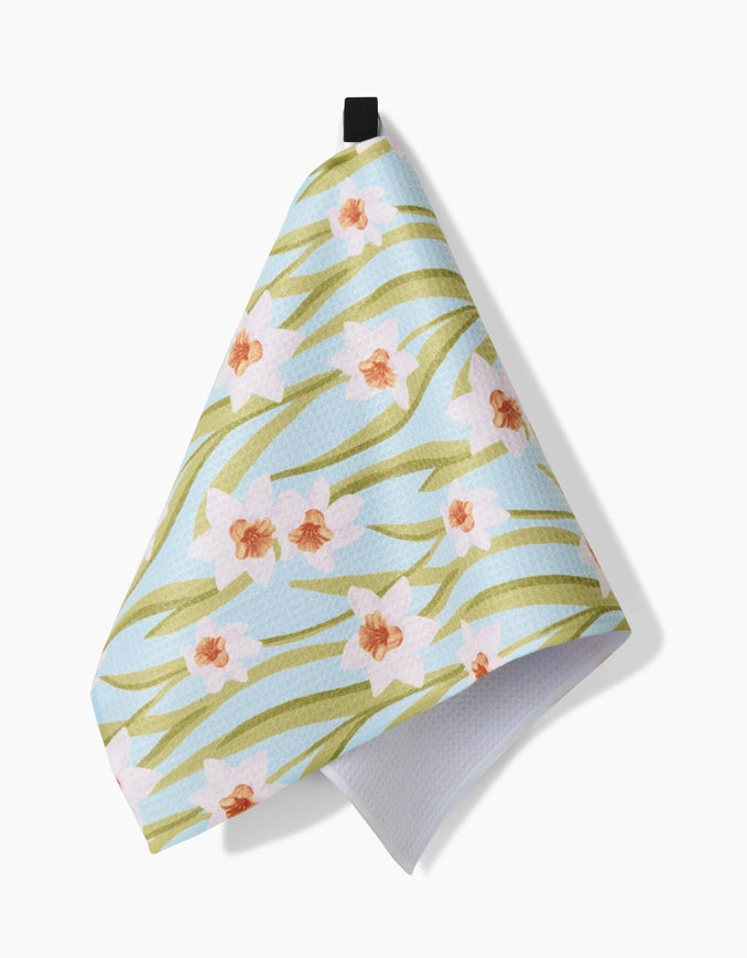 Floral patterned towel hanging on a hook against a white background