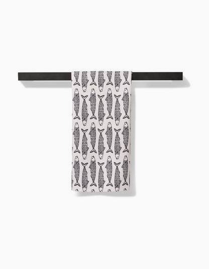 Towel with fish pattern hanging on a black rod against a white background