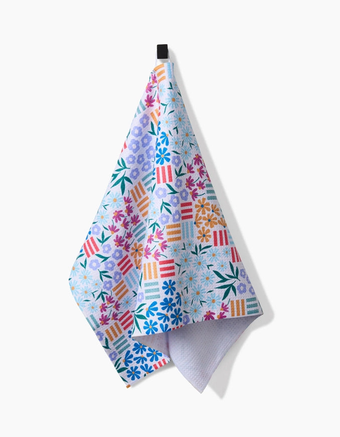 Colorful floral and geometric patterned towel on a white background