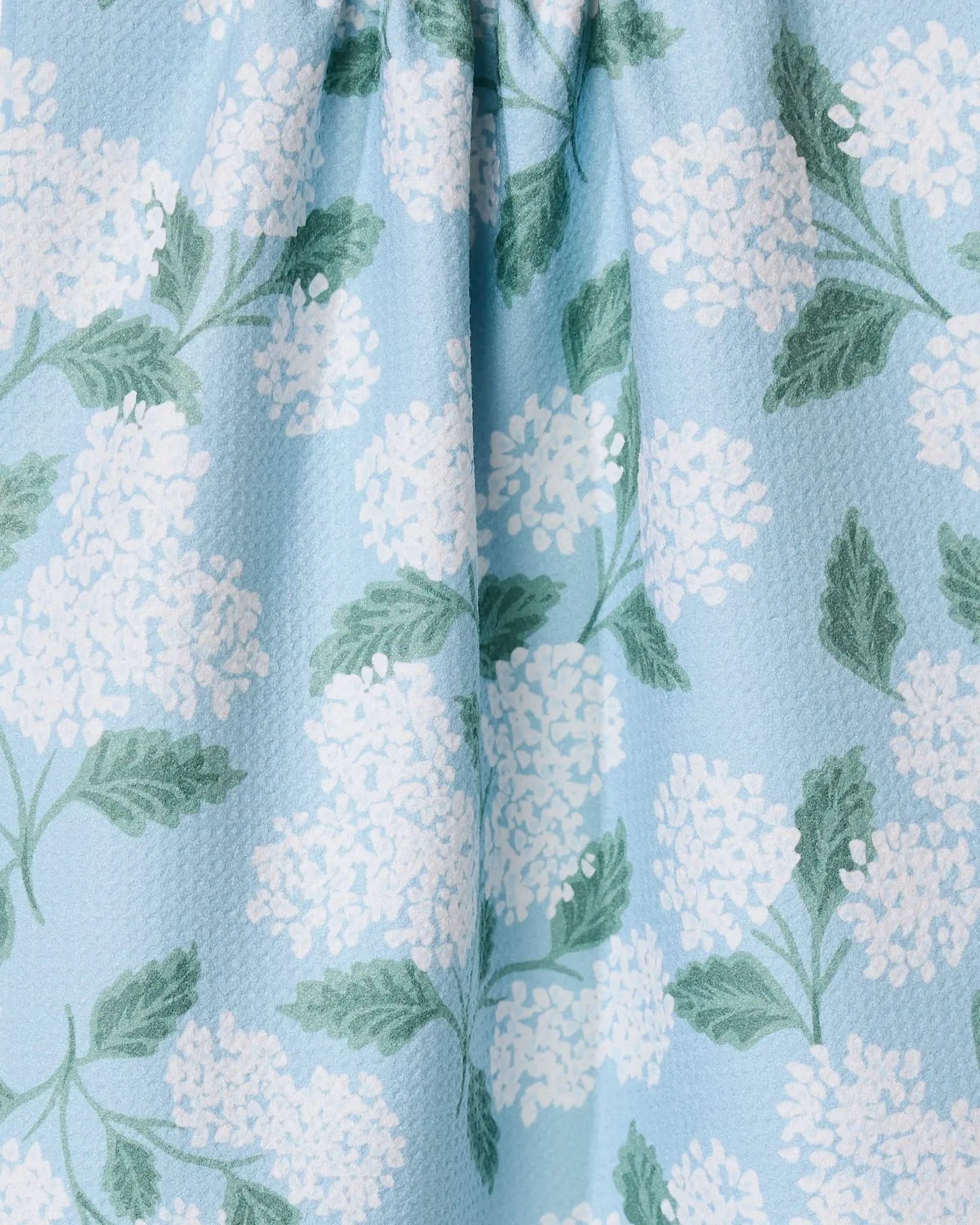 Floral pattern with white flowers and green leaves on a light blue background