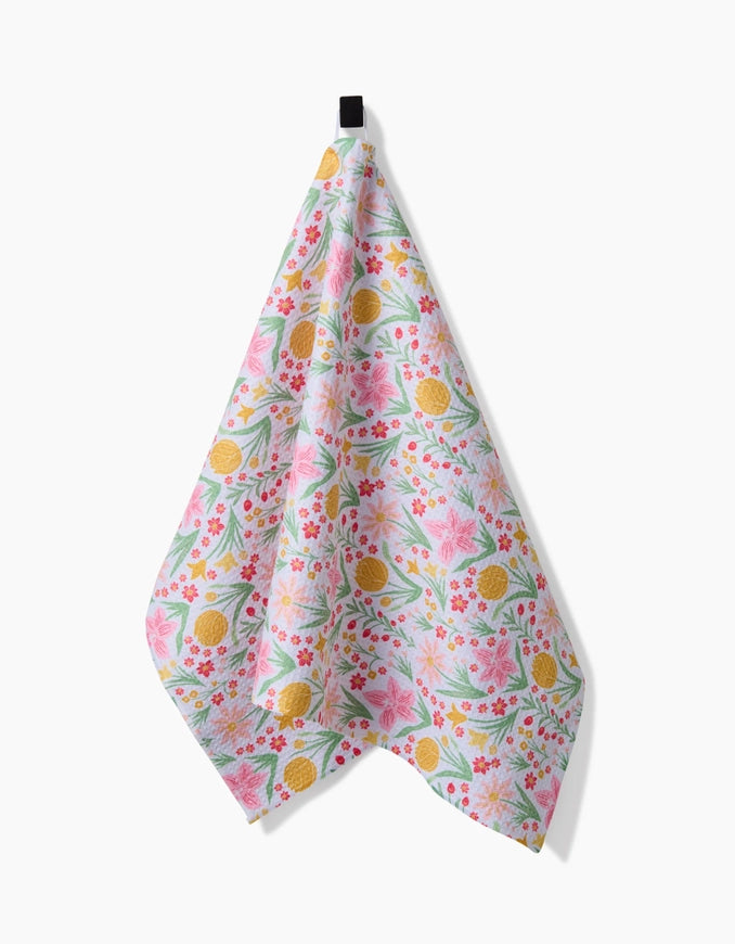 Floral patterned towel hanging on a hook against a white background
