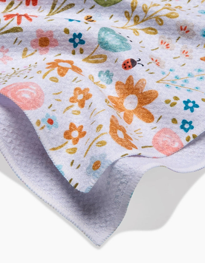 Floral patterned fabric with colorful flowers and leaves on a white background
