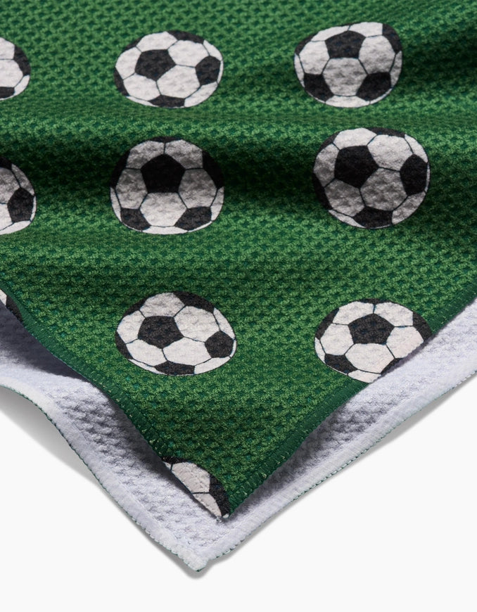 Green blanket with soccer ball pattern on a white background