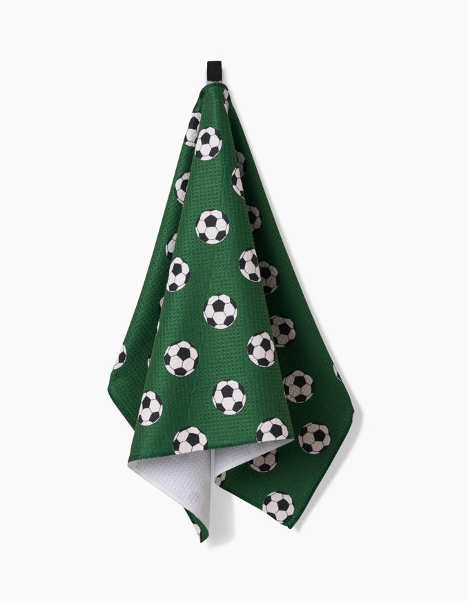 Green towel with soccer ball pattern hanging on a white background