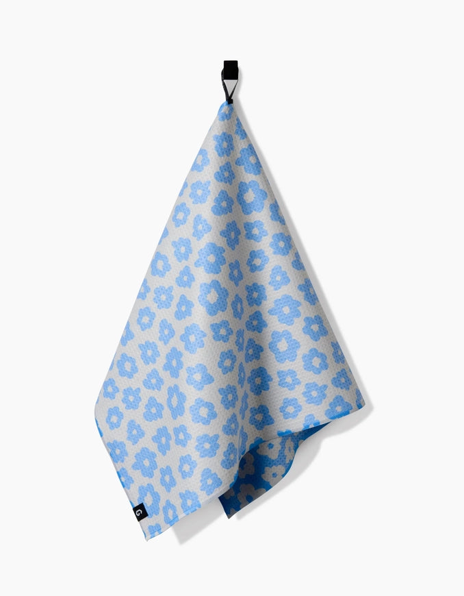 Blue floral patterned towel hanging on a white background