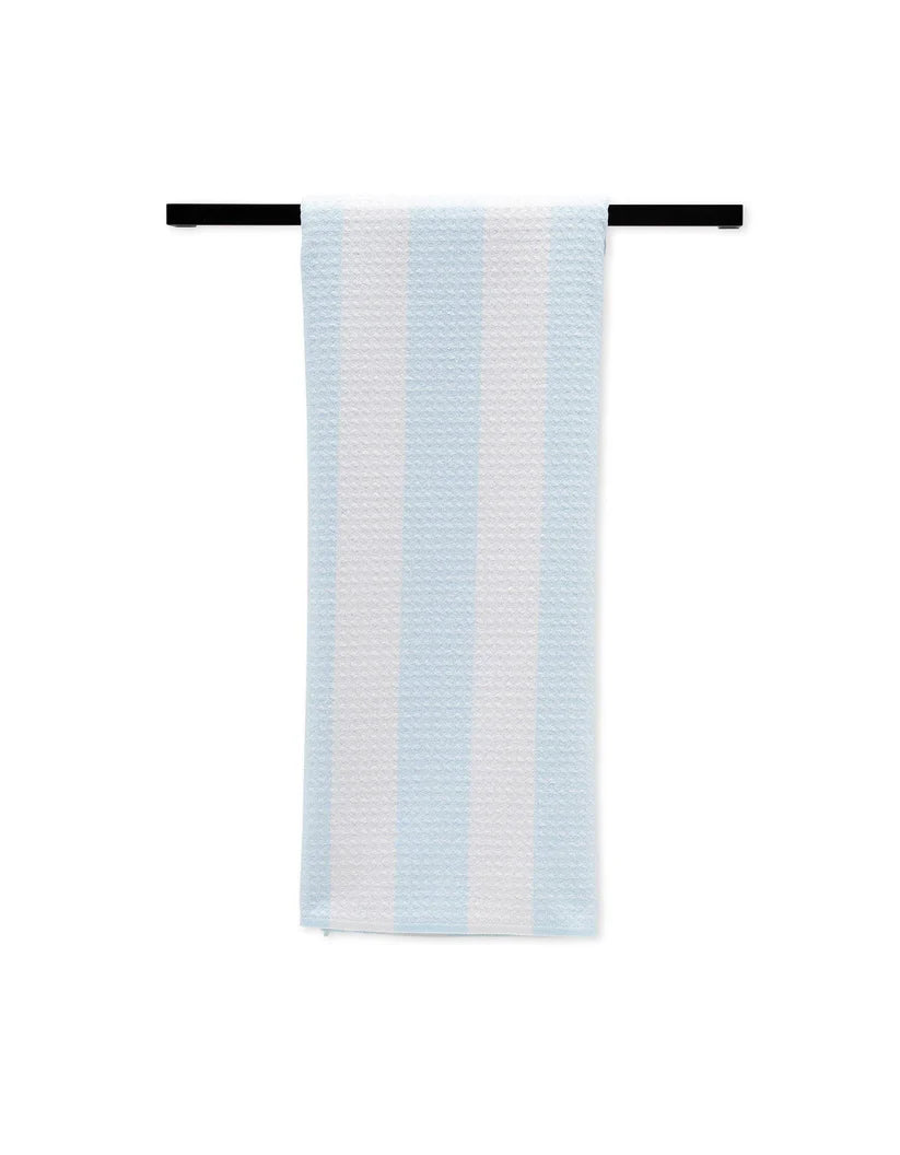 Striped towel hanging on a black rod against a white background