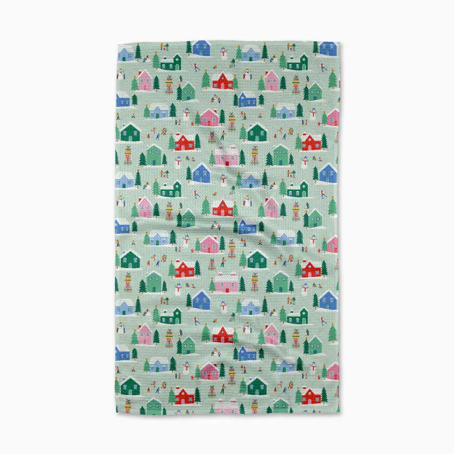 Fabric with a pattern of colorful houses and trees on a light green background