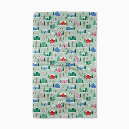 Fabric with a pattern of colorful houses and trees on a light green background