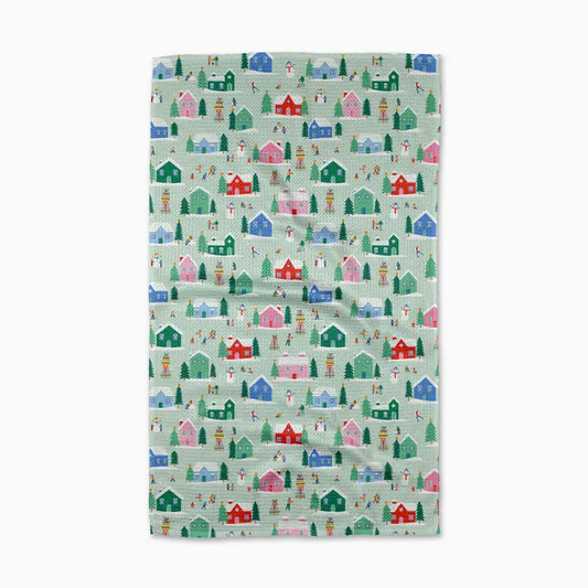 Fabric with a pattern of colorful houses and trees on a light green background