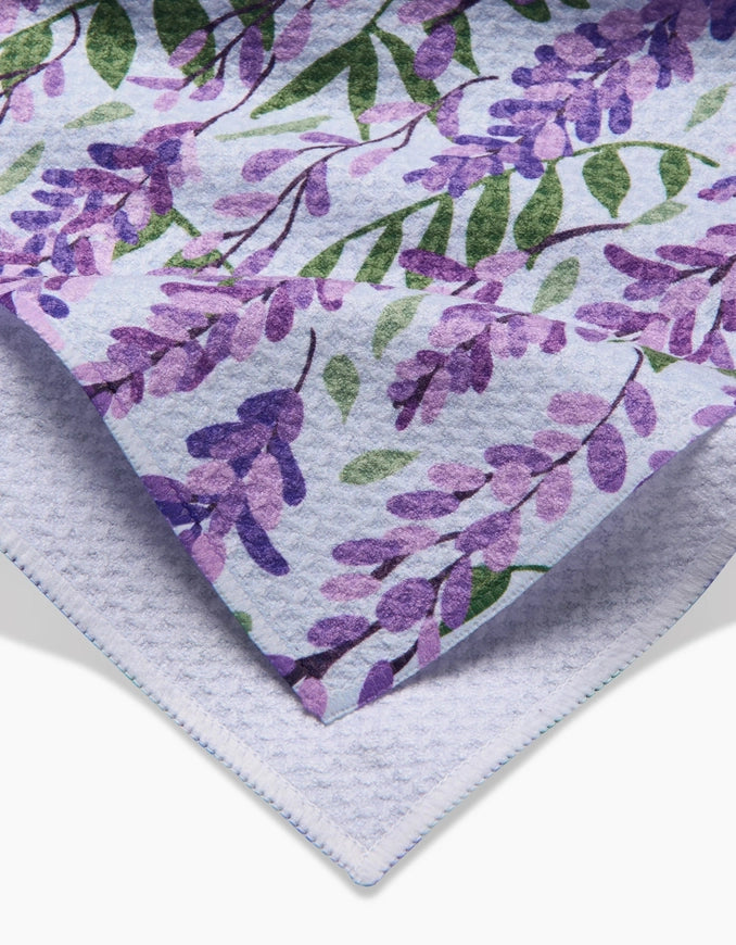 Floral patterned paper with purple flowers and green leaves on a white background