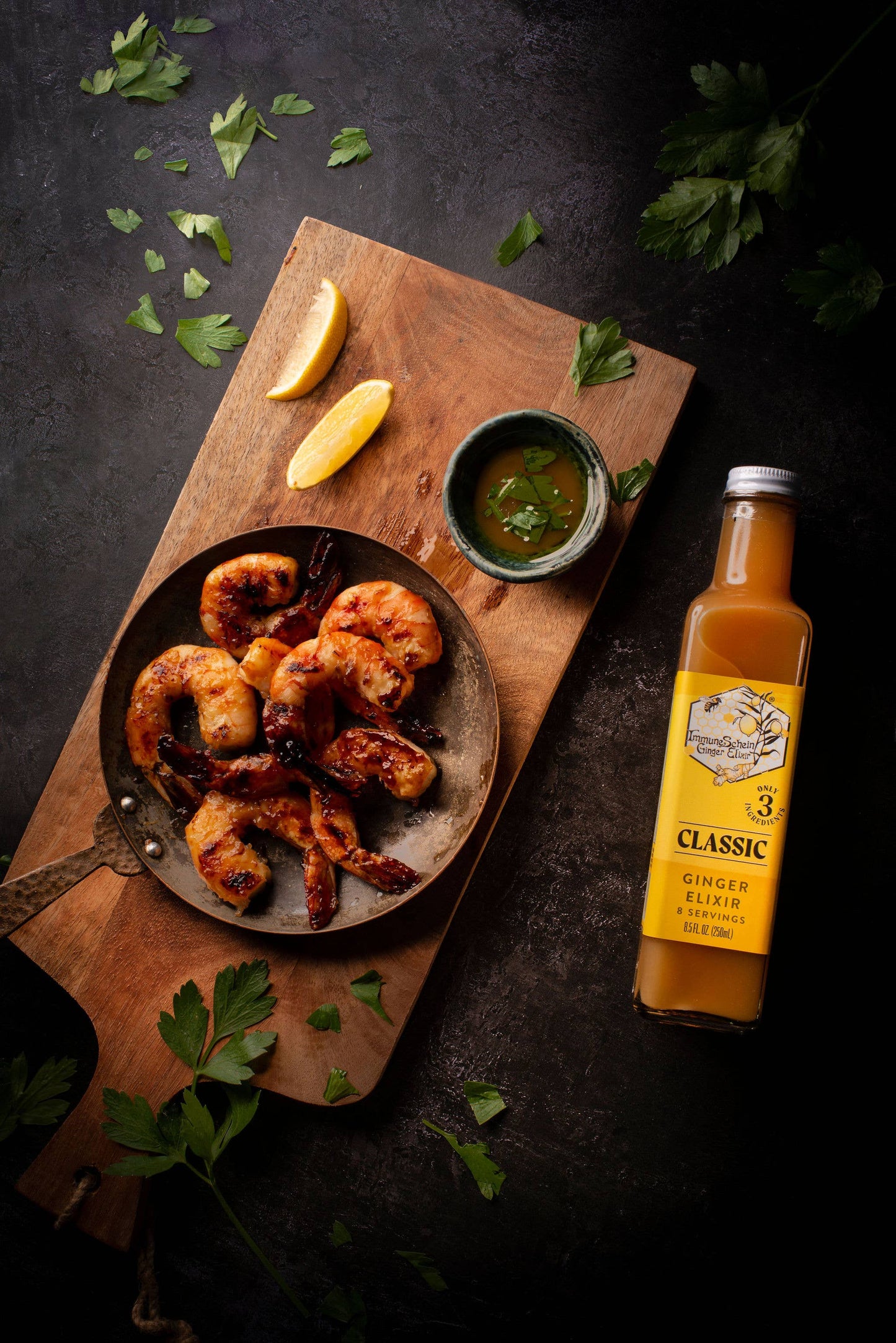 Garnished dish of fried food on a wooden board with a bottle of ginger beer.