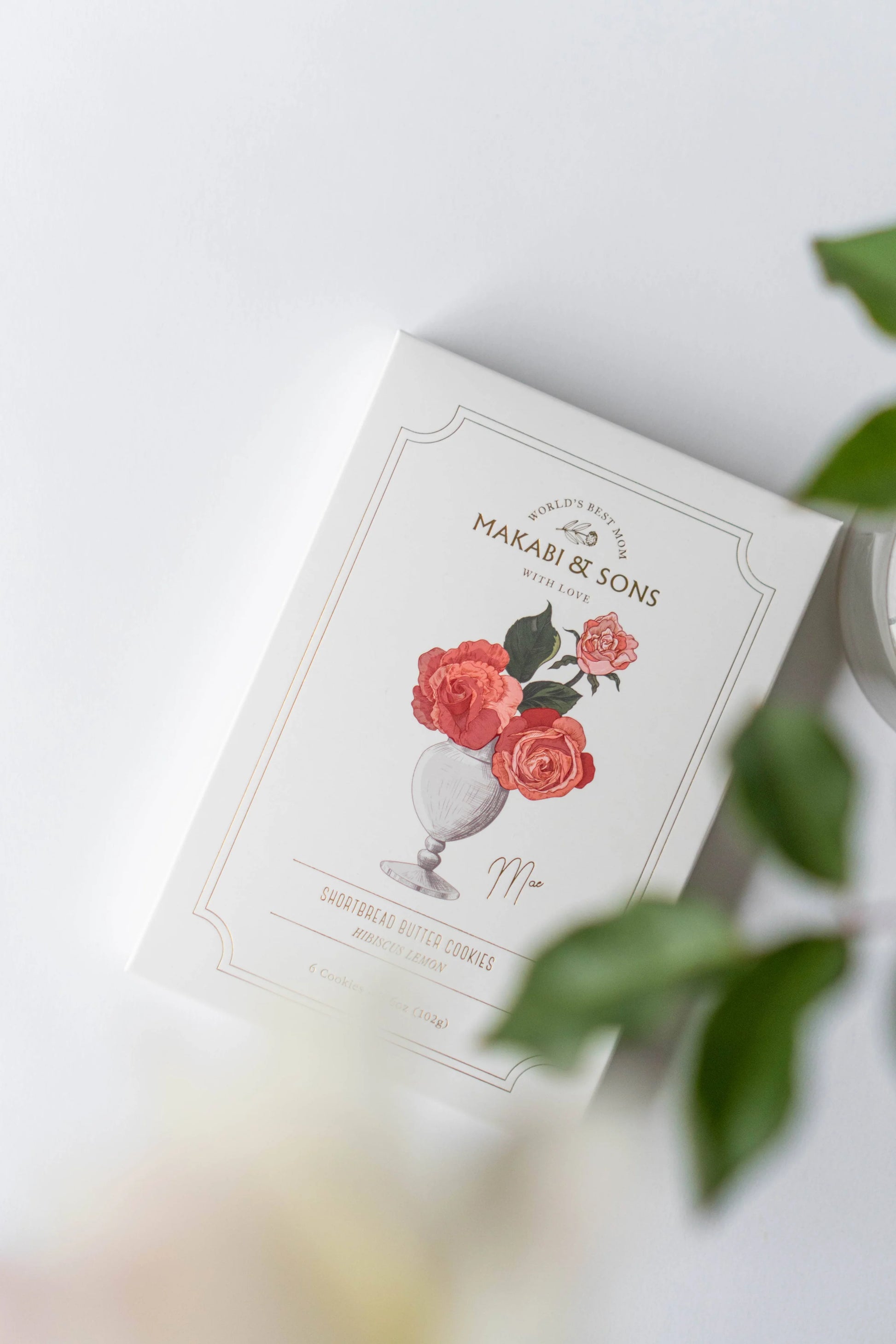 Product packaging with floral design and 'Makari & Sons' branding on a light background
