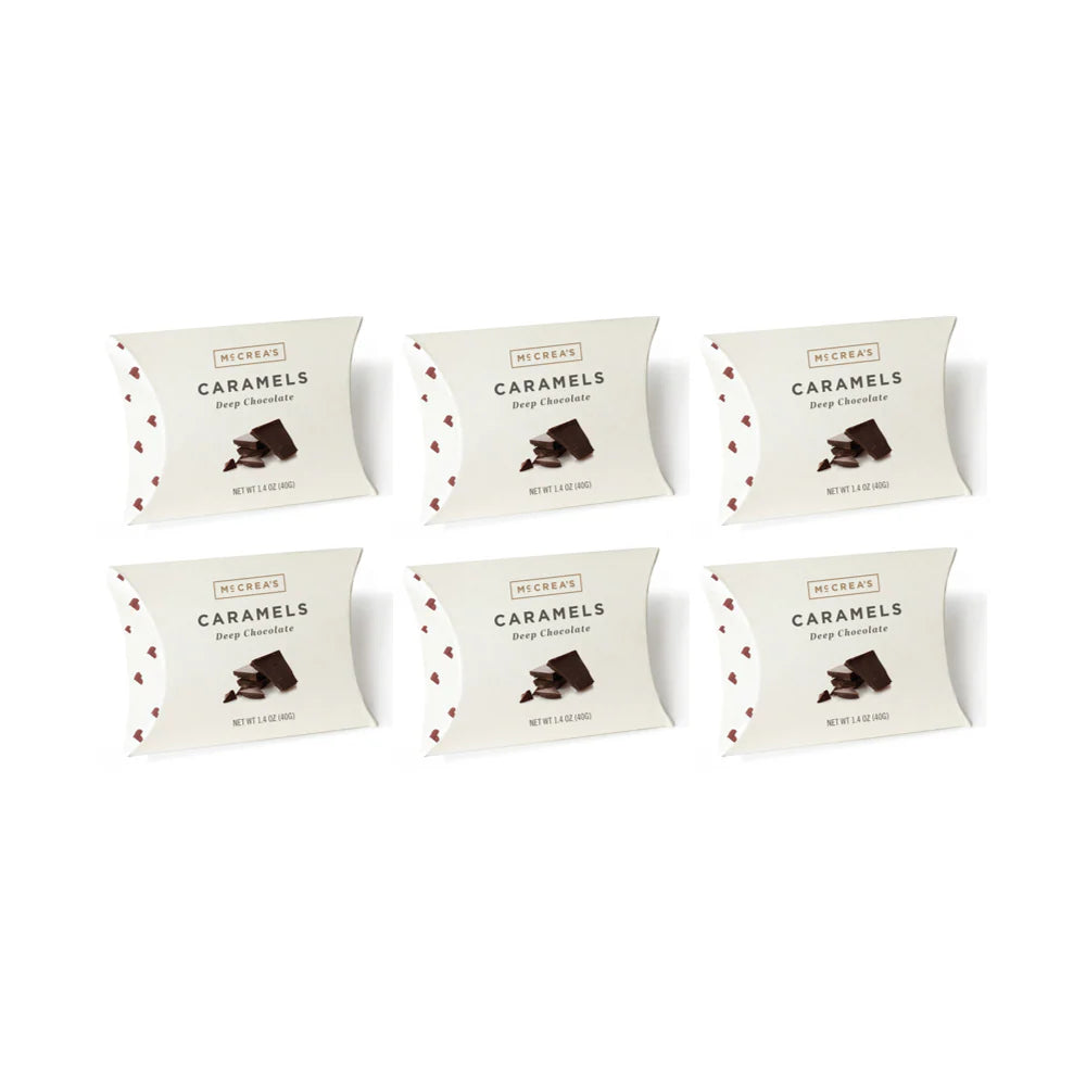 Six packages of Deep Chocolate Caramels on a white background