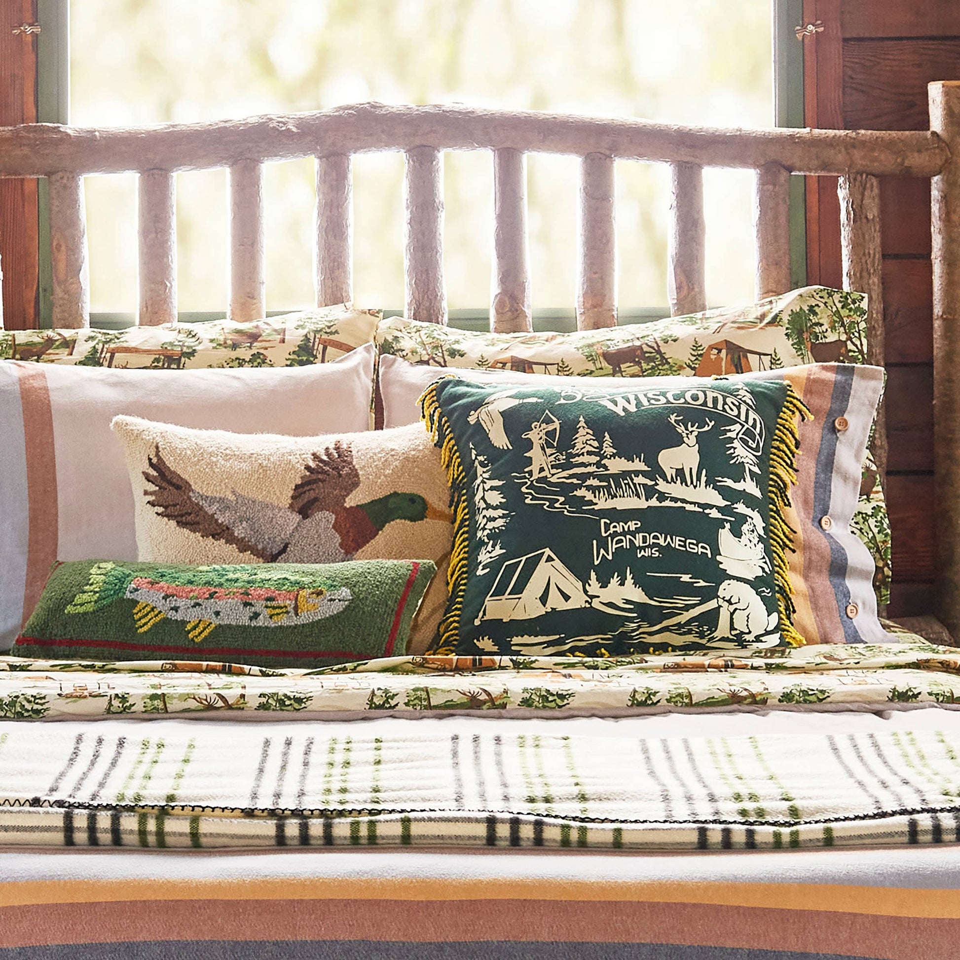 Decorative pillows with nature-themed designs on a wooden bench.