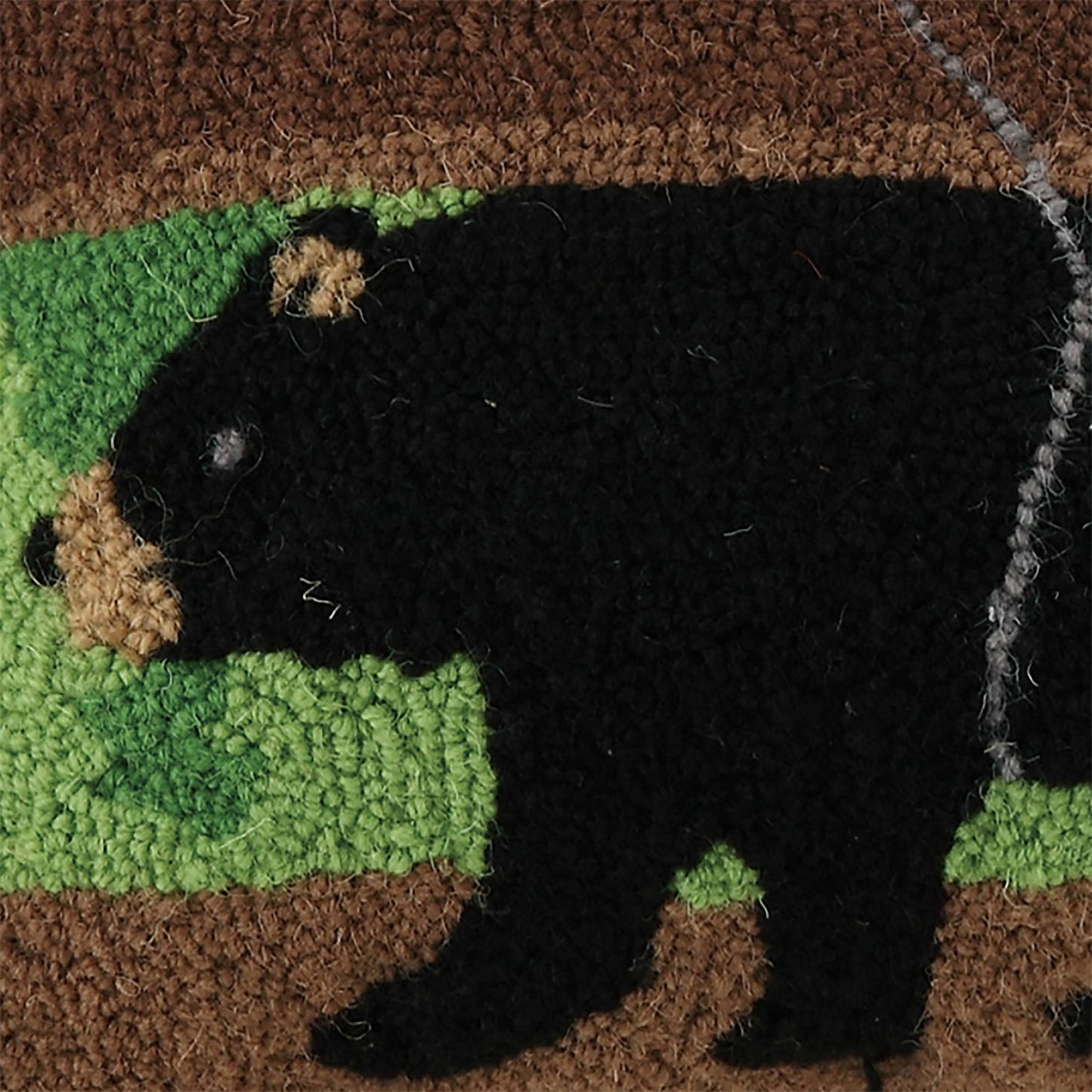 Doormat with a black bear design on a green patch, featuring natural textures.