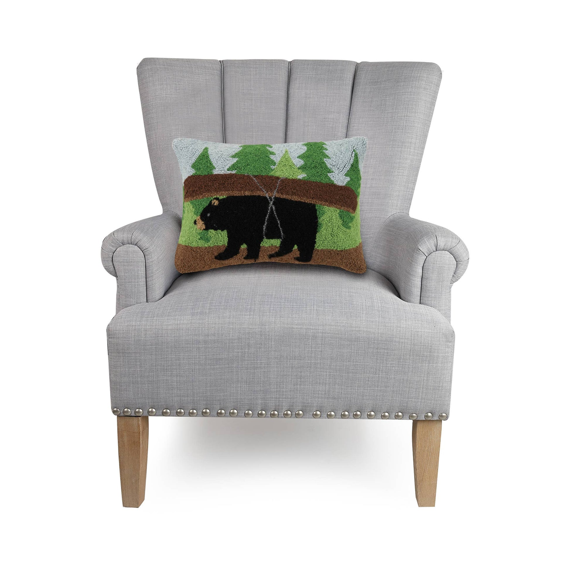 Gray armchair with a decorative pillow featuring a bear design on a white background