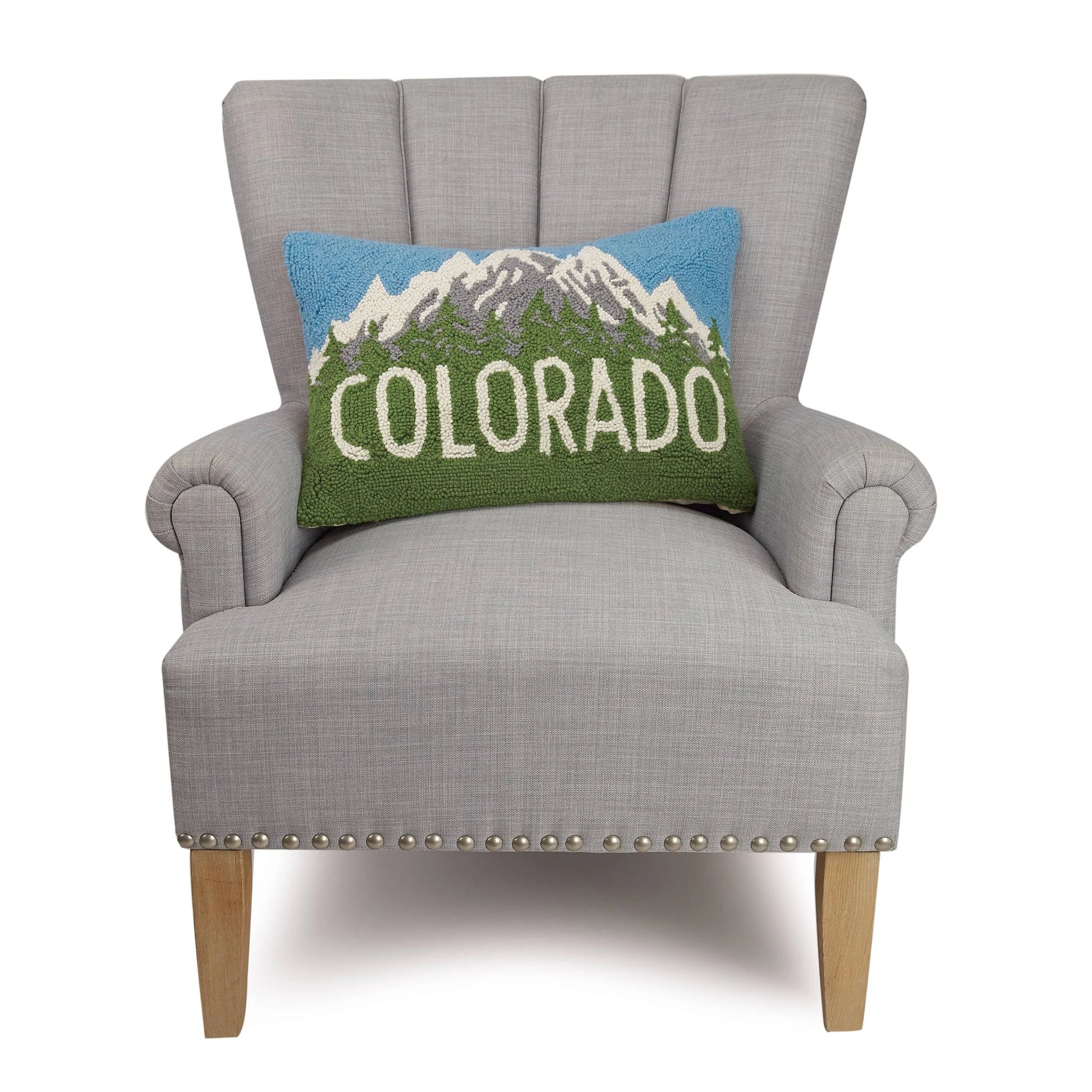 Gray armchair with a decorative pillow featuring mountains and 'Colorado' text on a white background