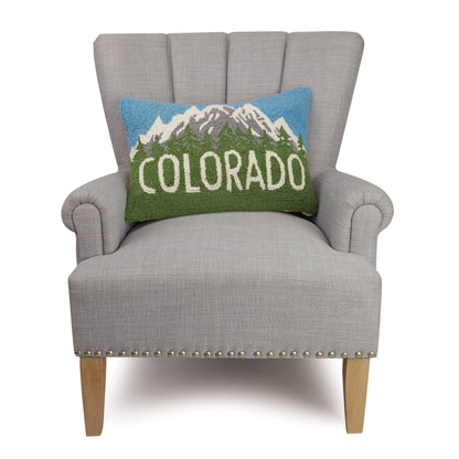 Gray armchair with a decorative pillow featuring mountains and 'Colorado' text on a white background