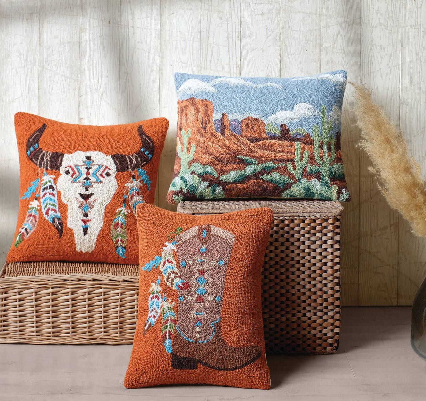 Three decorative pillows with Native American design on a woven basket against a wooden wall.