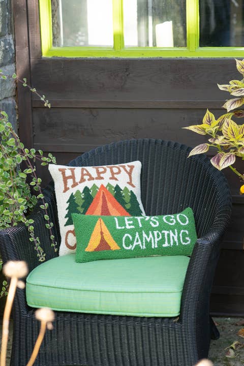 Chair with 'Happy Campers' and 'Let's Go Camping' pillows on a porch.