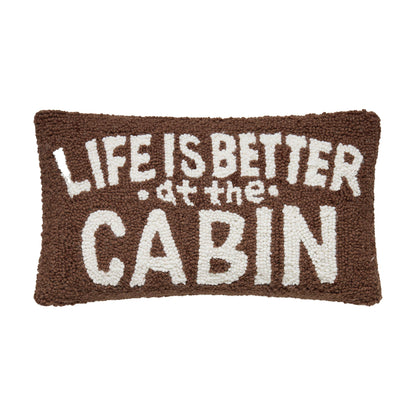 Textile product with 'Life is better at the cabin' text on a brown background