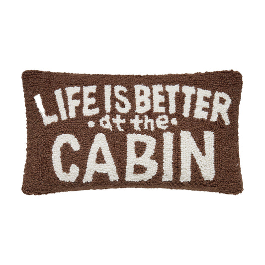 Textile product with 'Life is better at the cabin' text on a brown background