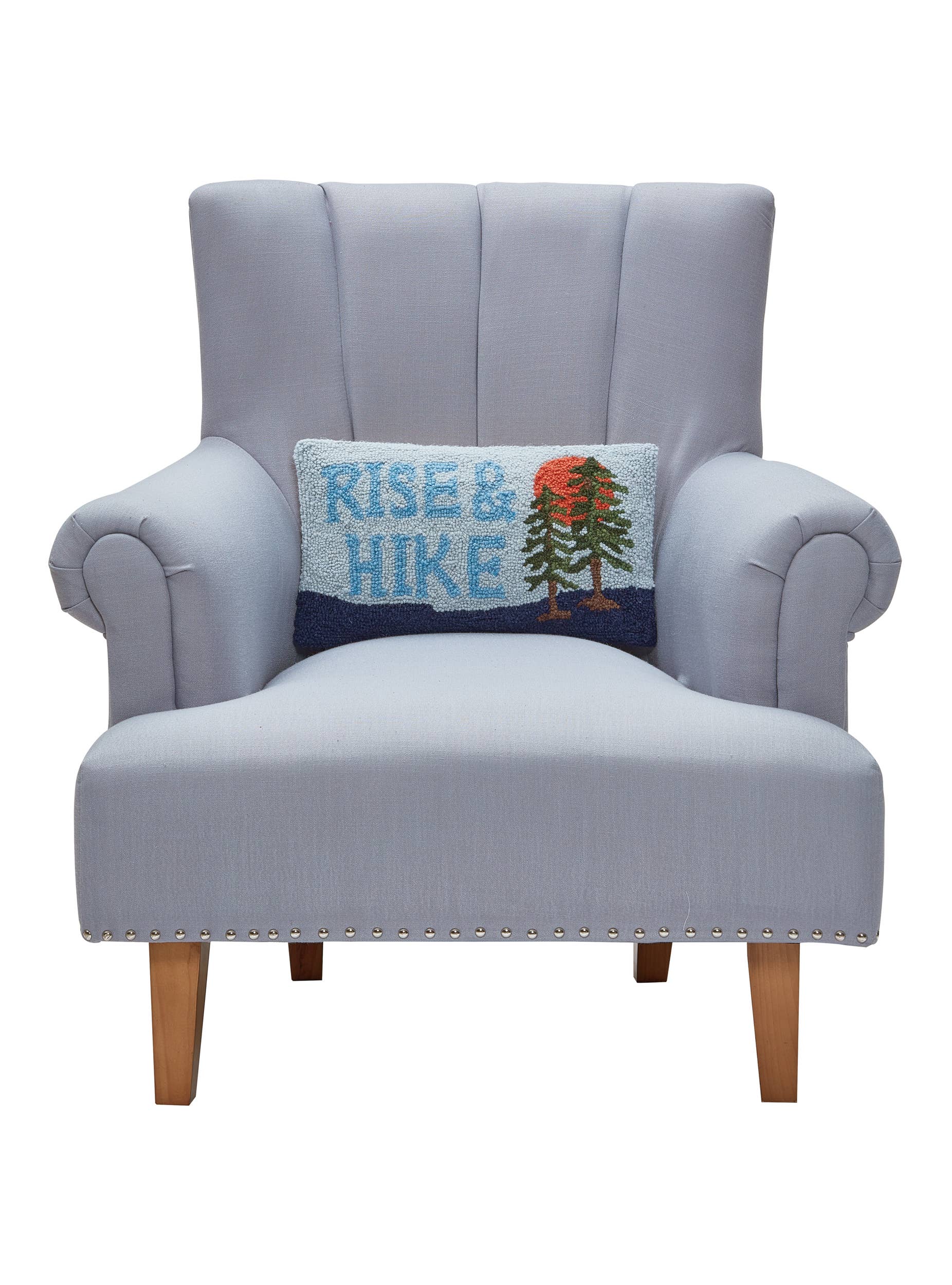 Gray armchair with a 'Rise & Hike' pillow on a white background