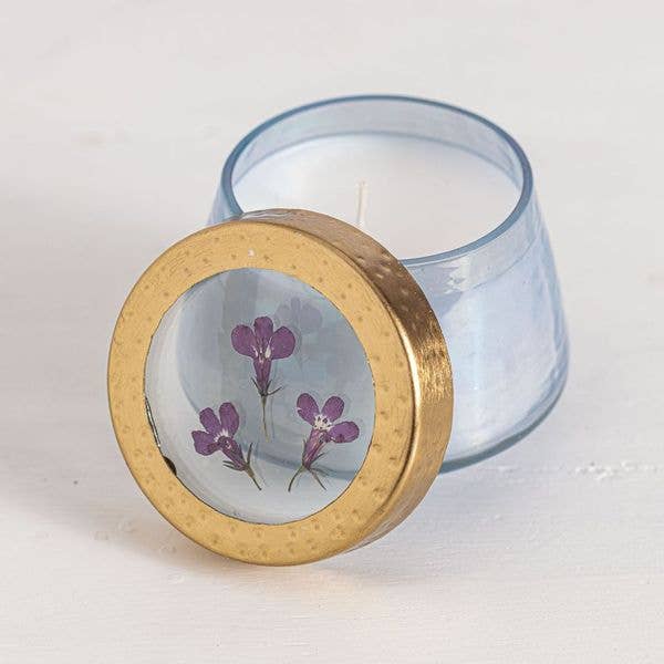 Candle with a decorative lid featuring floral design on a white background