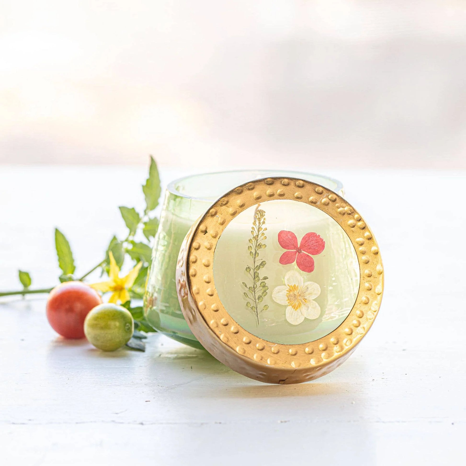 Decorative candle with floral design on a white surface
