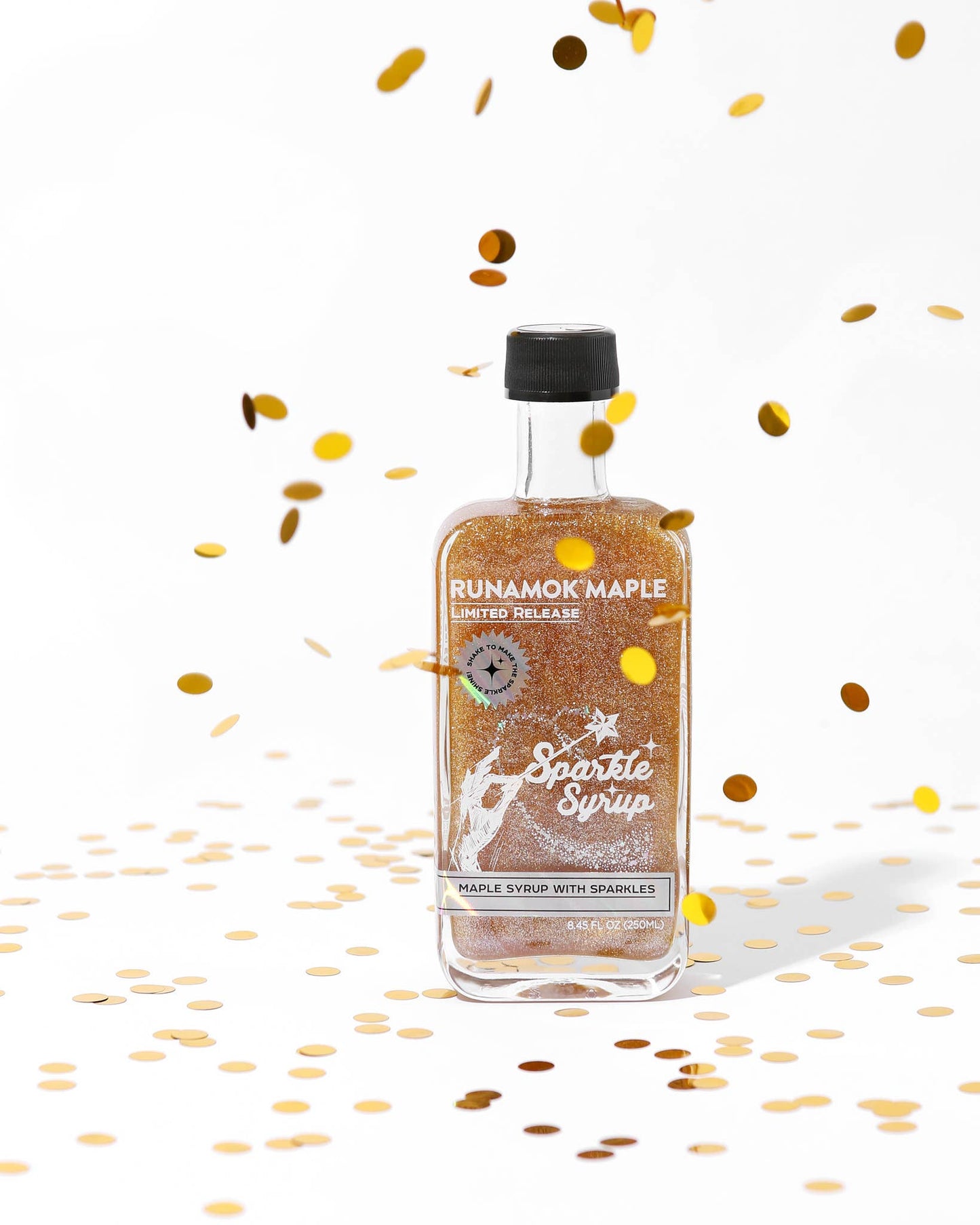 Bottle of Rumamok Maple Sparkle Syrup with confetti on a white background